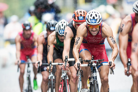 STOCKHOLM - AUG, 23: Cyclist with Francesco Godoy leading a group on the wet cobblestone road at the Mens ITU World Triathlon Series event August 23, 2014 in Stockholm, Swedenのeditorial素材