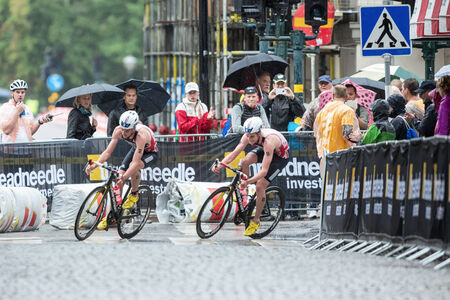 STOCKHOLM - AUG, 23: Triathletes Jonathan and Alistair Brownlee out of a curve on a wet cobblestone road in the Mens ITU World Triathlon Series event August 23, 2014 in Stockholm, Swedenのeditorial素材