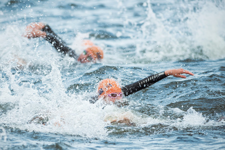 STOCKHOLM - AUG, 23: Triathletes swimming in the cold water at the Womans ITU World Triathlon Series event August 23, 2014 in Stockholm, Swedenのeditorial素材