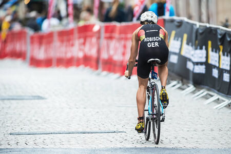 STOCKHOLM - AUG, 23: Back of Rebecca Robisch from Germany cycling in rain at the cobblestone road in the Woman ITU World Triathlon Series event August 23, 2014 in Stockholm, Swedenのeditorial素材
