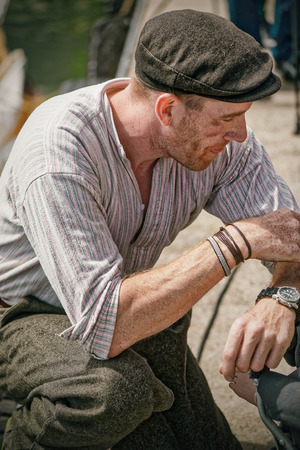 GRISSLEHAMN, Sweden - JUNE, 15: Exhausted rower in vintage clothes from one of the first postal boats reaching Grisslehamn, June 15, 2014, in Grisslehamn, Swedenのeditorial素材