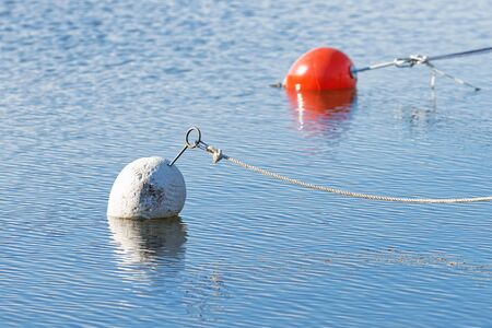 White marker bouy in foreground and a red one in the back. Swedenの写真素材