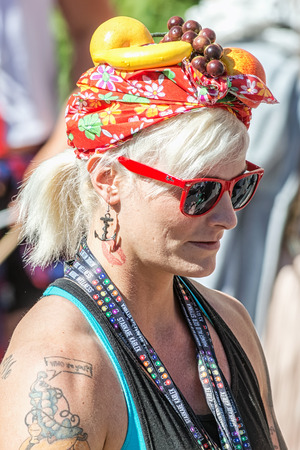 STOCKHOLM, SWEDEN - AUGUST 1, 2015: Blonde woman with fruits on head giving away neckbands at the Pride parade in Stockholm. Approx 400.000 spectators at the streets.のeditorial素材