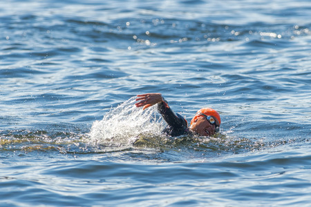 STOCKHOLM - AUG 22, 2015: Woman triathlete swimming in closeup at Womens ITU World Triathlon series event.のeditorial素材