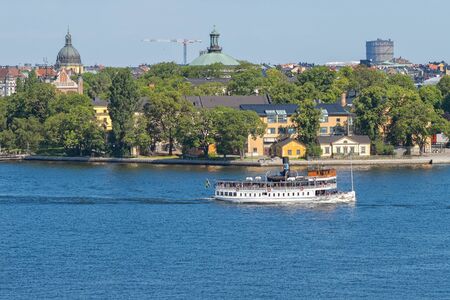 STOCKHOLM, SWEDEN - AUGUST 10, 2015: Waxholmsbolagets classic steamboat Norrskar with Skeppsholmen in background.のeditorial素材