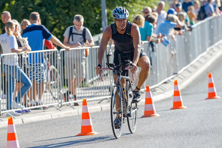 Photo pour STOCKHOLM - AUG 23, 2015: Triathlete braking before a curve at the ITU World Triathlon event in Stockholm. - image libre de droit