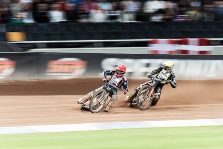 STOCKHOLM - SEPT 26, 2015: Two speedway racers in action at the TEGERA Stockholm FIM Speedway Grand Prix at Friends Arena in Stockholm.のeditorial素材