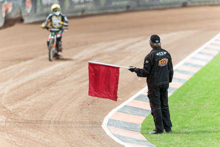 STOCKHOLM - SEPT 26, 2015: Referee stopping the race with a red warning flag at TEGERA Stockholm FIM Speedway Grand Prix at Friends Arena in Stockholm.のeditorial素材