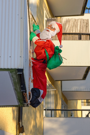 TULLINGE, SWEDEN - JAN 6, 2016: A doll of Santa or Father Christmas hanging from a balcony.のeditorial素材