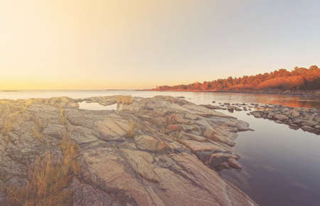Sunrise over coast with a natural pond and seagrass in foreground. Warm filters appliedの写真素材