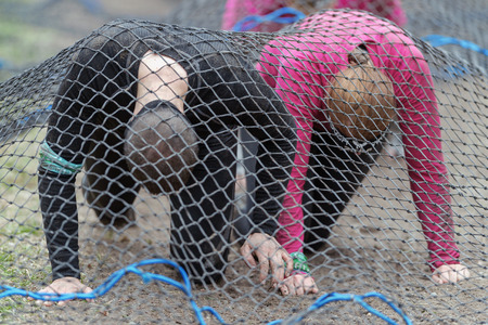 STOCKHOLM, SWEDEN - MAY 14, 2016 Crawling under the super net trap at Tough Viking obstacle course around Stockholm Stadion.のeditorial素材