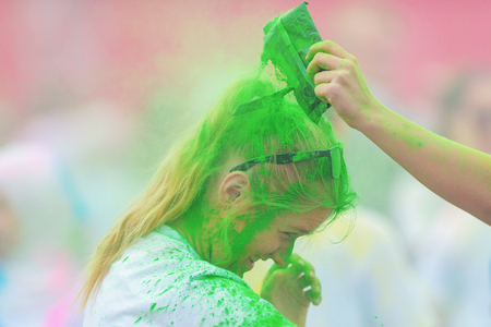 STOCKHOLM, SWEDEN - MAY 22, 2016: Blonde girl covered in green color at Color Run Tropicolor world tour in Stockholm.のeditorial素材