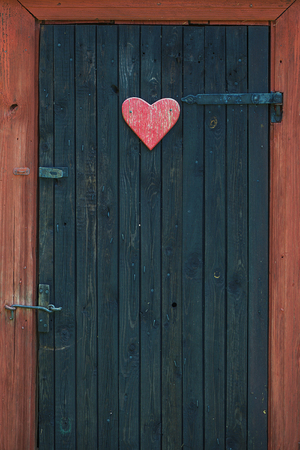 Traditional vintage restroom or lavatory outside with a heart sign on the black door. Swedenの写真素材