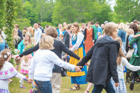 SINGO, SWEDEN - JUNE 24, 2016: People celebrating midsummer with dance around the maypole. Traditional event in Swedenのeditorial素材