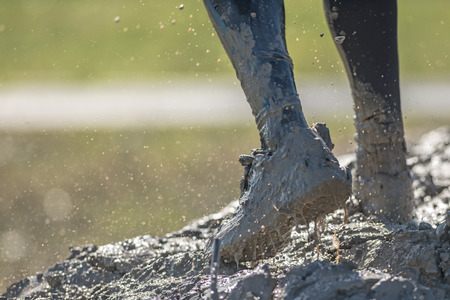STOCKHOLM, SWEDEN - AUG 27, 2016: Mud Charge by Backstrom at the Tough Viking event at Gardet in Stockholm. Shoe spashing in mud and forcing forwardのeditorial素材