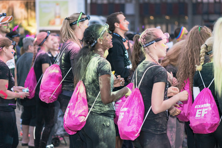 STOCKHOLM, SWEDEN - SEPT 18, 2016: Friends throwing color at each other at the Color Run Night...