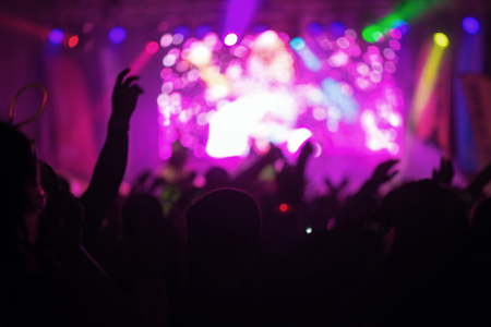 STOCKHOLM, SWEDEN - SEPT 18, 2016: Hands and arms silhouette of happy people infront of the stage at the Color Run Night Edition in Stockholm.のeditorial素材