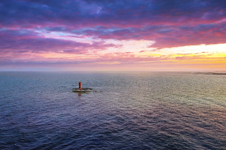 Beacon on a small island during a colorful sunset in the swedish archipelago at summertimeの写真素材