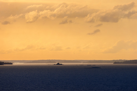 Majestic view of the swedish archipelago partly lit during sunset with great cloudscape. Swedenの写真素材