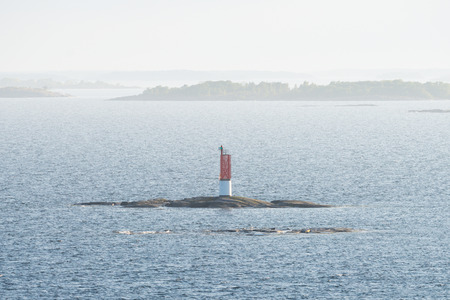 Red beacon on a small rock at a seaway. Swedenの写真素材