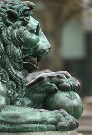 Side view of a bronze sculpture of a royal lion with the paws on a ball with the three crowns. Swedenのeditorial素材