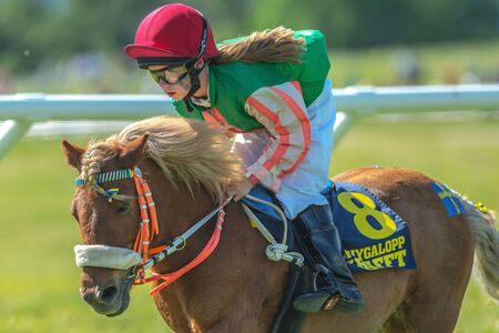 STOCKHOLM, SWEDEN - JUN 6, 2017: Young girl jockey in the pony race at Nationaldagsgaloppen at Gardet.のeditorial素材