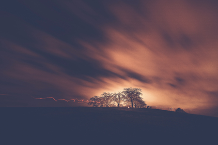 Woodland cemetary outside of Stockholm with dramatic sky and some motion blur during all saints night. Filteredの写真素材