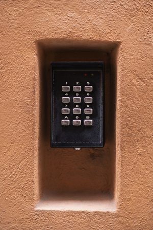 Numeric codelock inside a orange plastered stone wall. Sweden