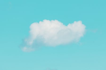 Single white fluffy cloud on turquoise sky. Good as backgroundの写真素材