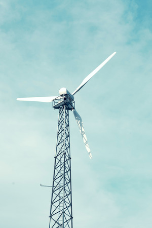 Windmill in a small scale powering a farm with electricity with blue sky in background. Swedenの写真素材