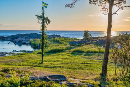 Sunrise of a classic midsommer pole at the green coast of Roslagen, Sweden