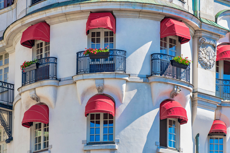 STOCKHOLM, SWEDEN 29 JUNE, 2019. Red colorful blinders at the white ornamented hotel Diplomat with french balconys facing StrandvÃ¤gen in Stockholm during summer.のeditorial素材