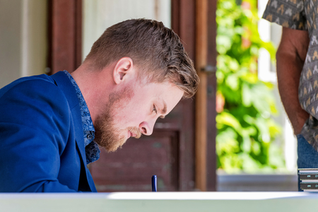 GRISSLEHAMN, SWEDEN, JULY 6, 2019: Emil Maxen winner of the Albert Engstrom prize 2019 signing his books after the cermony.のeditorial素材