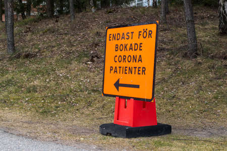 HUDDINGE, SWEDEN - APRIL 13, 2020: Closeup of a orange Corona sign at Huddinge hospital.