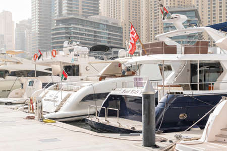 DUBAI, UAE - JAN 24, 2019: Yachts packed tight togheter at the Dubai marina with highrise resedential buildings in background.のeditorial素材