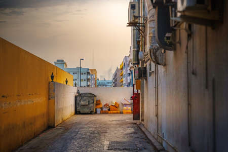DUBAI, UAE - JAN 24, 2019: Dubai back alley with air conditioners and trash with the city center in the hazy horison. Burj Khalifa from Burjuman district.のeditorial素材