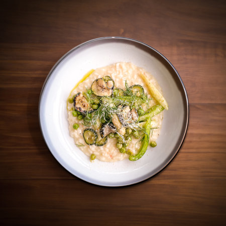 Creamy asparagus risotto with fresh vegetables with sprinkel of parmesan.の写真素材