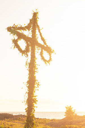 Sunrise of a classic midsommer pole in sunlit warm colors at the coastline of Roslagen. Swedenの写真素材