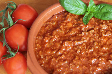 Bolognese meat sauce with tomatoes on a wooden boardの写真素材