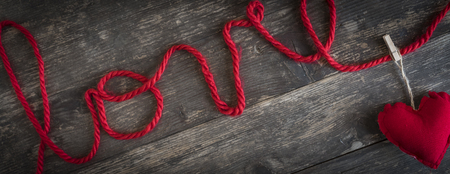 the word love written with a red woolen thread