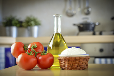 in the kitchen, on the table, tomatoes, mozzarella and oil. The typical products of the healthy Mediterranean diet with which the most classic of Italian pizzas are prepared: the margherita pizzaの写真素材