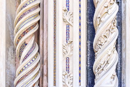 Detail of the facade of the cathedral of Orvieto, Umbria, Italy. Spiral marble columns decorated...