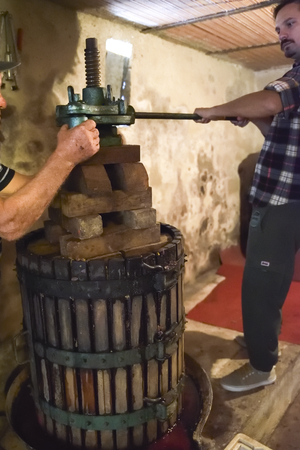 Winemaking. Old wooden wine press with must inside. Pressing of grapes for red wineの写真素材