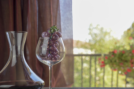 Italian red wine inside the decanter and goblet with decorations. Natural backgroundの写真素材