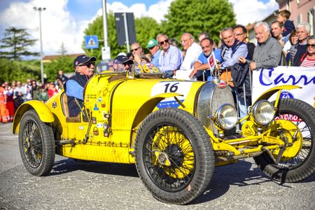 Amelia, Italy, May 2018. Mille Miglia (1000 Miles), historical vintage car race. Two men driving a historic Bugatti, color yellow. On the roadのeditorial素材