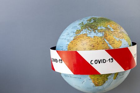 Planet earth with caution barrier tapes. Fight and prevention against coronavirus. Global quarantine concept. In the foreground Europe, Africa, Asia. Light backgroundの写真素材