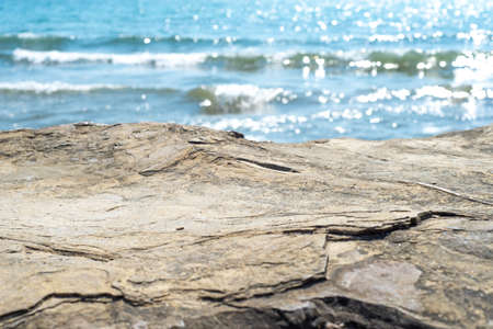 Empty cliff stone with summer blue sea blur background. Copy space for display of product on online...
