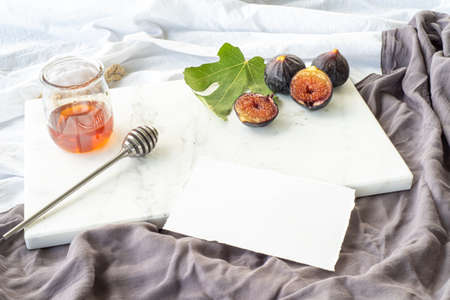 Autumn breakfast still life. Cup of coffee, fig fruit, bread with butter and jam on wooden chop board. Breakfast in bed, fall food concept.の写真素材