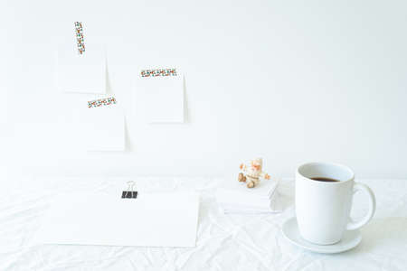 Christmas or New Year breakfast scene. Notepad mockup of good intentions. Blank note paper hanging on the wall. Coffee cup, Santa Claus, empty paper sheet on the deskの写真素材