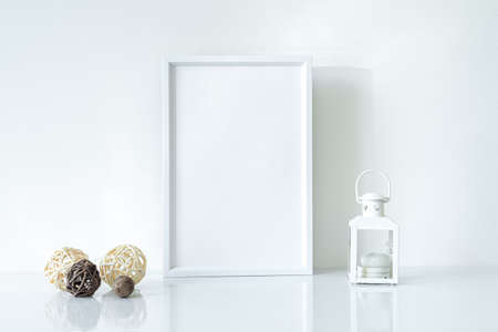 Mock up white frame with Christmas lantern and decorations on shelf. Portrait frame against a white wallの写真素材